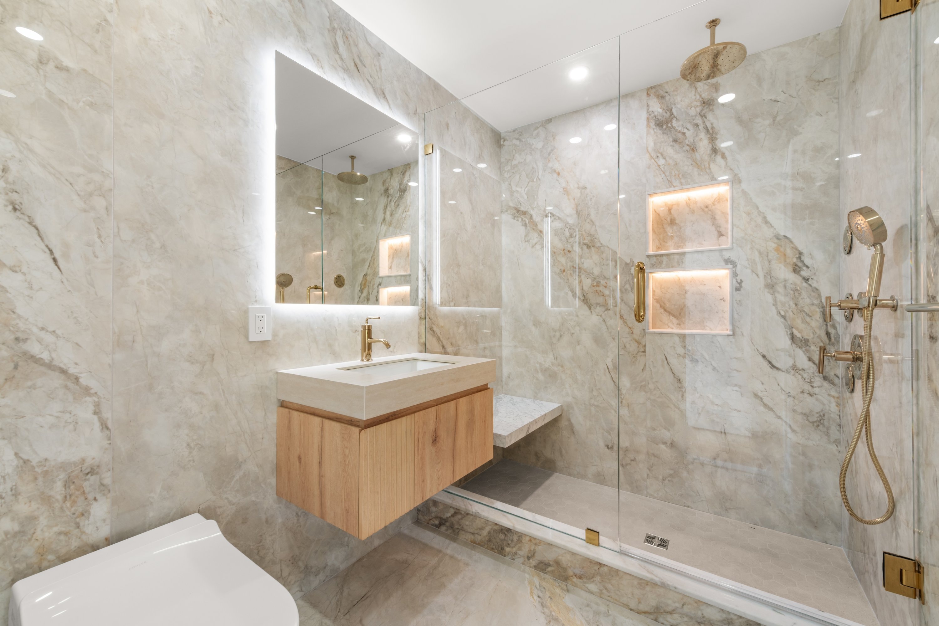 Secondary bathroom with marble tile and brass fixtures