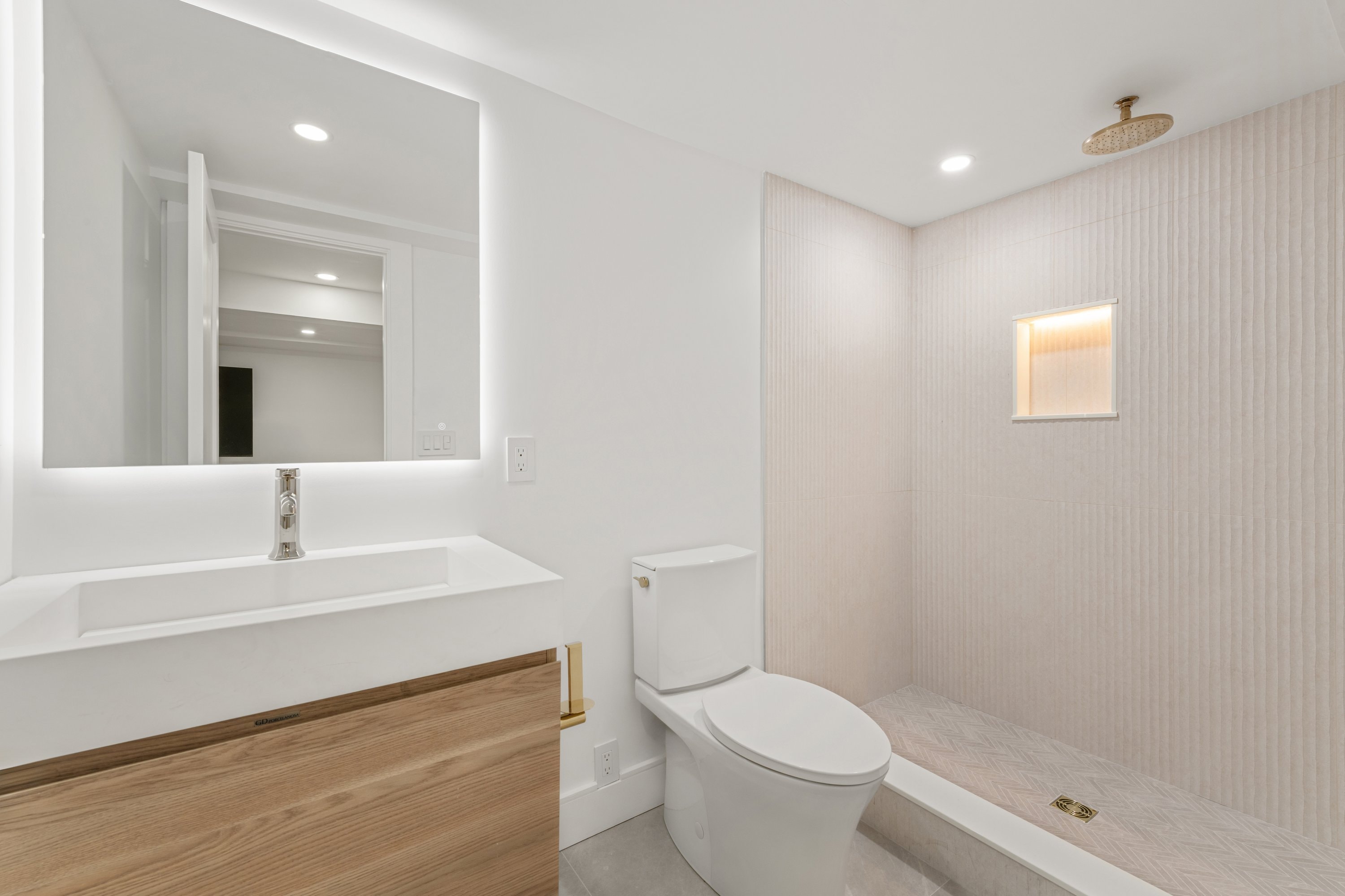 Modern bathroom with backlit mirror and textured tile shower
