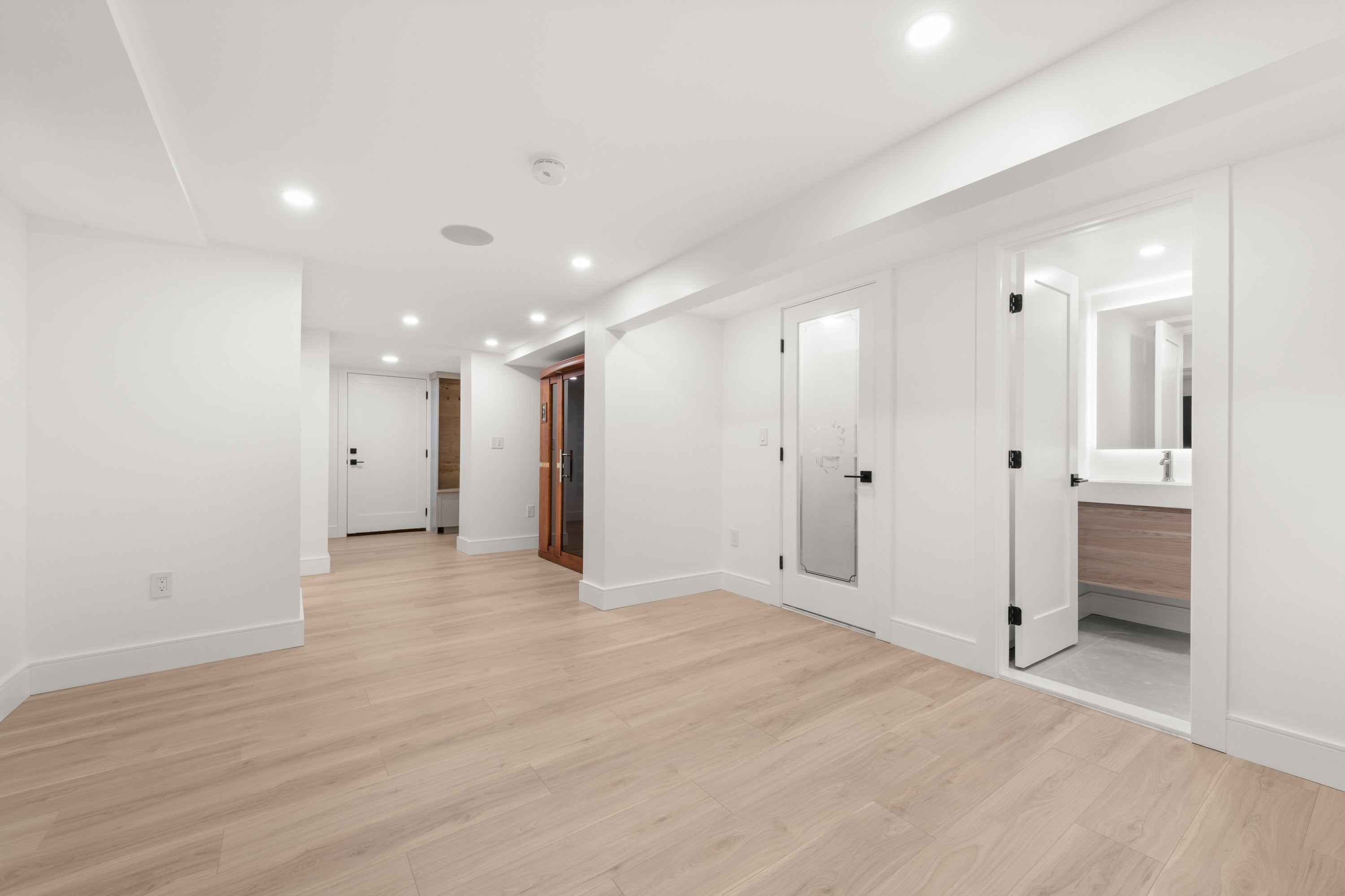 Lower level hallway with sauna and light wood flooring