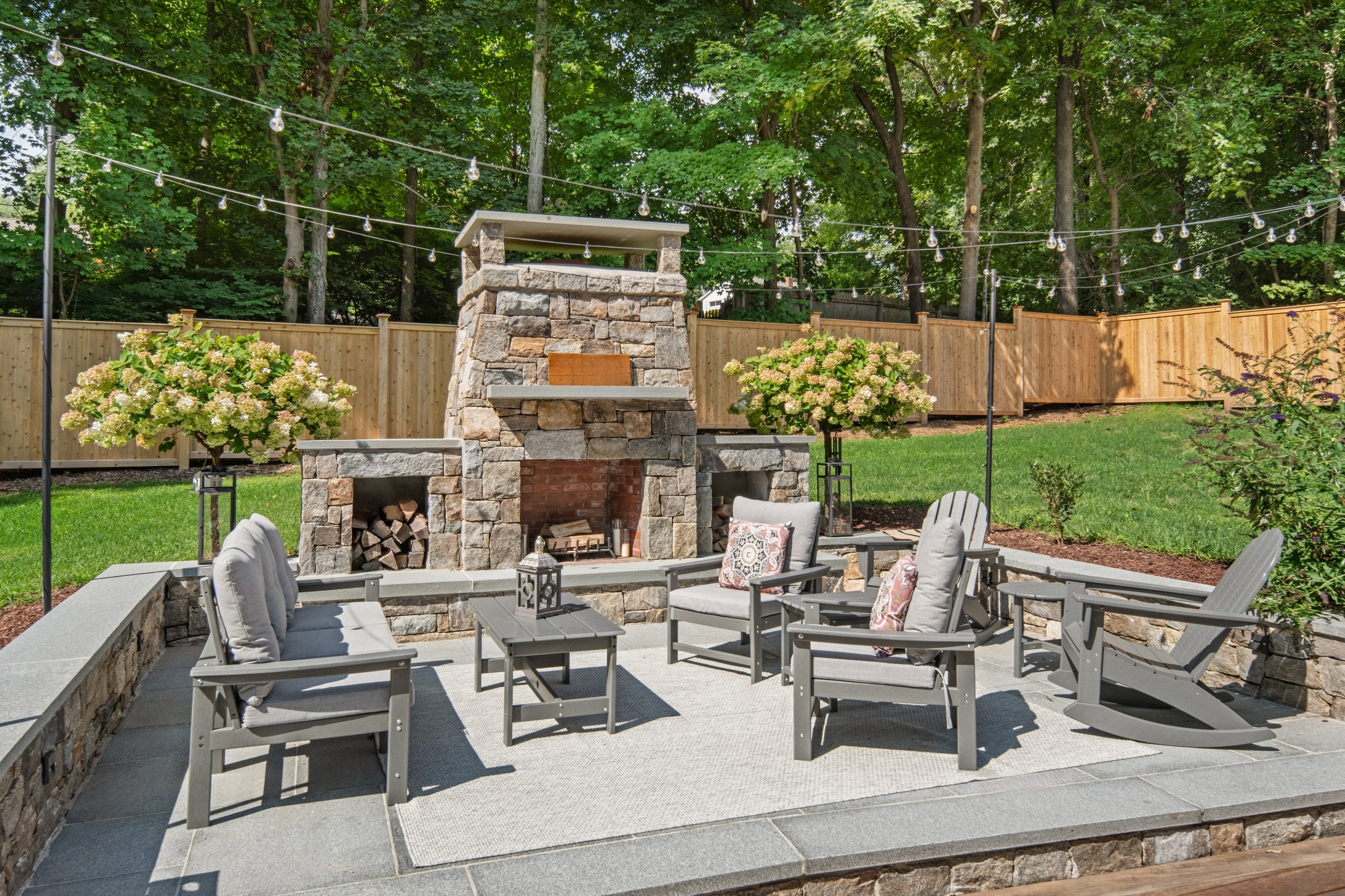 Custom stone outdoor fireplace with bluestone patio and seating area, Fairfield County CT